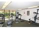 Well-equipped exercise room with various machines, large windows overlooking a balcony, and bright overhead lighting at 6415 Midnight Pass Rd # 508, Sarasota, FL 34242