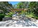 Outdoor grilling area featuring stone pavers, brick surround, two gas grills, and a wooden pergola above at 6415 Midnight Pass Rd # 508, Sarasota, FL 34242