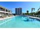 Resort-style pool with poolside seating and a view of the building and tropical surroundings at 6415 Midnight Pass Rd # 508, Sarasota, FL 34242