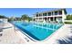 Community pool with clear blue water, lounge chairs, and building in the background at 6415 Midnight Pass Rd # 508, Sarasota, FL 34242