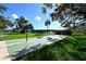 Community shuffleboard court with surrounding green grass, mature shade trees, and bay views at 6415 Midnight Pass Rd # 508, Sarasota, FL 34242