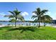 Picturesque waterfront view with Adirondack chairs scattered along the waterfront lawn at 6415 Midnight Pass Rd # 508, Sarasota, FL 34242