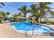 Sparkling community pool featuring a rock waterfall, surrounded by lush palm trees at 6606 Holmes Blvd # 3, Holmes Beach, FL 34217