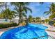 Beautiful pool with waterfall feature, surrounded by palm trees and lush greenery at 6606 Holmes Blvd # 3, Holmes Beach, FL 34217