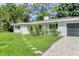 Exterior view of a house with a well-manicured lawn, stone path, and attached garage at 6624 Fairway Dr, Sarasota, FL 34243