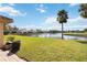 Lawn leading to a serene lake view surrounded by mature trees at 6637 Deering Cir, Sarasota, FL 34240