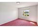 Bedroom featuring a pink carpet and a window overlooking a serene lake view at 6637 Deering Cir, Sarasota, FL 34240