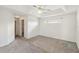 Spacious carpeted bedroom featuring tray ceiling, ceiling fan, and a walk-in closet at 6637 Deering Cir, Sarasota, FL 34240