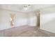 Large carpeted bedroom featuring a ceiling fan and an entrance to an outdoor patio space at 6637 Deering Cir, Sarasota, FL 34240