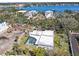 Aerial view of a property with a pool, surrounded by trees, with a waterfront community nearby at 6640 Peacock Rd, Sarasota, FL 34242