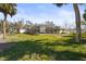 Lush backyard showcasing a well-maintained lawn and mature landscaping around a home with a screened enclosure at 6640 Peacock Rd, Sarasota, FL 34242