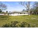 Large backyard featuring a lush lawn, mature trees and a view of the side and rear of the home at 6640 Peacock Rd, Sarasota, FL 34242