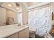 Bright bathroom featuring a single sink vanity with a marble-themed shower curtain at 6640 Peacock Rd, Sarasota, FL 34242