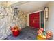 Inviting front porch with double red doors, stone accents, and colorful potted plants at 6640 Peacock Rd, Sarasota, FL 34242