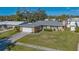 A high-angle view of a single-Gathering home showcasing the green lawn and paved driveway at 6716 Keystone Dr, Sarasota, FL 34231