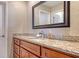 Bathroom with granite countertops, a decorative mirror, and wooden cabinets at 6716 Keystone Dr, Sarasota, FL 34231