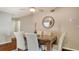 Dining room with a glass-top table, upholstered chairs, and a decorative mirror on the wall at 6716 Keystone Dr, Sarasota, FL 34231