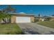 Single-story home with a two-car garage, small garden, and a neatly kept lawn at 6716 Keystone Dr, Sarasota, FL 34231