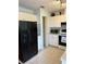 Efficient kitchen with white cabinetry, black appliances, and a built-in microwave at 7109 Java Dr, Sarasota, FL 34241