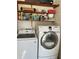 Bright laundry area features newer Samsung washer and dryer, and shelving for storage at 7109 Java Dr, Sarasota, FL 34241