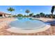 Serene community pool with a shallow area, surrounded by lush landscaping and lounge chairs at 7140 Marsh View Ter, Bradenton, FL 34212