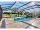 Enclosed pool area featuring a spa and tile floors, and view of the yard at 7140 Marsh View Ter, Bradenton, FL 34212