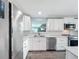 Well-lit kitchen with white cabinets, stainless steel appliances, and mosaic backsplash at 7225 Las Casas Dr, Sarasota, FL 34243