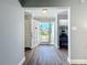 Open entryway with gray wood floors and white door, with a peek into the office space at 7225 Las Casas Dr, Sarasota, FL 34243