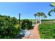 Community beach access showcasing a wooden walkway, greenery, and an outdoor shower facility at 775 Longboat Club Rd # 406, Longboat Key, FL 34228