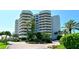 Contemporary condo building with lush landscaping and inviting entrance at 775 Longboat Club Rd # 406, Longboat Key, FL 34228