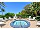 Outdoor hot tub area featuring tile design, lush landscaping, and surrounding deck chairs, perfect for relaxation at 775 Longboat Club Rd # 406, Longboat Key, FL 34228