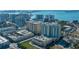 Stunning aerial view showcasing high-rise condo in coastal city with water views, a rooftop pool, and nearby amenities at 800 N Tamiami Trl # 1217, Sarasota, FL 34236