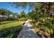 Picturesque community path winding through lush greenery, inviting residents to enjoy serene walks and peaceful outdoor spaces at 800 N Tamiami Trl # 1217, Sarasota, FL 34236