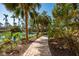 Charming brick path by a pond, surrounded by tropical foliage, enhancing the tranquil ambiance of the community at 800 N Tamiami Trl # 1217, Sarasota, FL 34236