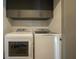 Laundry room showcasing a front-load washer and dryer with storage at 800 N Tamiami Trl # 1217, Sarasota, FL 34236