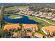 An aerial view shows condos with a golf course, pond and lush landscaping at 8414 Wethersfield Run # 102, Lakewood Ranch, FL 34202