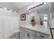 Well-lit bathroom with updated vanity, framed art and a shower with a curtain at 8414 Wethersfield Run # 102, Lakewood Ranch, FL 34202