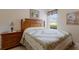 Cozy bedroom with wooden furniture and a decorative quilt on the bed, lit by natural light at 8414 Wethersfield Run # 102, Lakewood Ranch, FL 34202