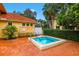 A brick patio includes a hot tub surrounded by tropical plants and hedges at 8414 Wethersfield Run # 102, Lakewood Ranch, FL 34202