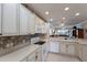 Spacious kitchen featuring white cabinets, modern appliances, and a view into the living area at 8414 Wethersfield Run # 102, Lakewood Ranch, FL 34202