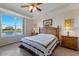 This main bedroom features a large window, wood furniture, and lake views at 8414 Wethersfield Run # 102, Lakewood Ranch, FL 34202