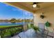 Relaxing screened patio with a table set, overlooking a serene water view and lush greenery at 8414 Wethersfield Run # 102, Lakewood Ranch, FL 34202