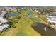 Aerial of the golf course winding through a lush landscape and around sparkling ponds at 905 Barclay Ct, Venice, FL 34293