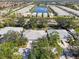 Aerial view of a community showcasing the homes, a central lake, and surrounding trees at 905 Barclay Ct, Venice, FL 34293