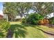 Lush backyard featuring green grass, mature trees, and well-maintained landscaping at 905 Barclay Ct, Venice, FL 34293