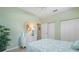 Bright bedroom features a white dresser, oval mirror, and a bed with a floral patterned coverlet at 905 Barclay Ct, Venice, FL 34293