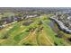 Scenic aerial view of a lush golf course with ponds and manicured green, nestled in a residential community at 905 Barclay Ct, Venice, FL 34293