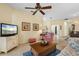 Bright living room features a ceiling fan, tile floors, and easy access to other areas of the house at 905 Barclay Ct, Venice, FL 34293