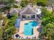 Aerial view of a community pool with lounge chairs and umbrellas surrounded by lush landscaping at 905 Barclay Ct, Venice, FL 34293