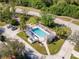 Aerial view of a neighborhood pool with lounge seating surrounded by lush landscaping at 905 Barclay Ct, Venice, FL 34293